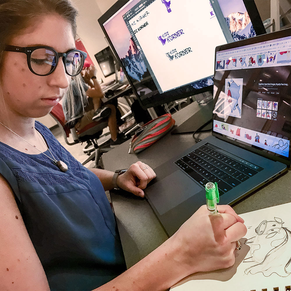 A student designer draws out sketches for a logo design.